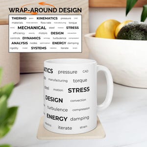 May include: White ceramic mug with a wrap-around design featuring engineering terms such as "STRESS", "DESIGN", and "ENERGY". The mug is on a light-coloured coaster. The words are in a black, sans-serif font.