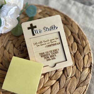 May include: A wooden teacher appreciation gift with a cross and the name "Ms. Smith" cut out. The text reads "Let all that you do be done in love. 1 Corinthians 16:14" and "Thank you for being a wonderful teacher! From Aiden B. 2025-2026."
