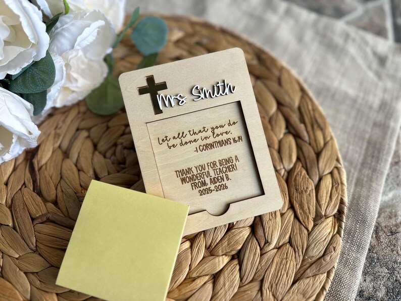 May include: A wooden teacher appreciation gift with a cross and the name "Ms. Smith" cut out. The text reads "Let all that you do be done in love. 1 Corinthians 16:14" and "Thank you for being a wonderful teacher! From Aiden B. 2025-2026."