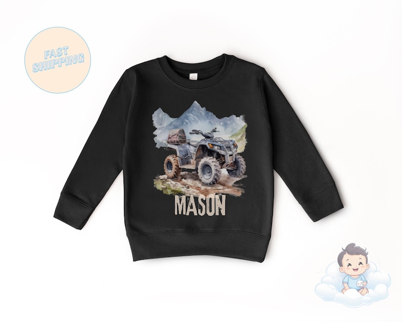 K&ouml;nnte beinhalten: Schwarzes Langarm-Sweatshirt mit einer Aquarell-Illustration eines ATVs auf einem schlammigen Pfad und Bergen. Der Name "MASON" ist darunter gedruckt. Das Sweatshirt ist f&uuml;r Kinder.