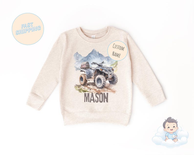 K&ouml;nnte beinhalten: Ein beiges Sweatshirt mit einer Aquarellillustration eines ATVs auf einem Bergpfad. Der Name "MASON" ist unter dem ATV aufgedruckt. Die Worte "CUSTOM NAME" stehen auf einem Aufkleber. Die Worte "FAST SHIPPING" stehen auf einem Aufkleber.