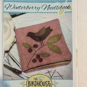 May include: A packaged needlebook with the title "Winterberry Needlebook" in script. The needlebook is a square, dusty rose color with a brown bird and green leaves design. The Birdhouse Patchwork Designs logo is at the bottom.