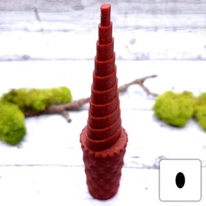 May include: A red plastic spiral coil tool for making crafts. The tool has a series of graduated rings that can be used to create different sizes of coils.