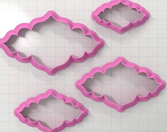 May include: Set of four pink plastic cookie cutters shaped like ornate frames. The cutters are different sizes and have a decorative design.