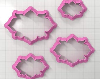 May include: Set of four pink plastic cookie cutters in the shape of a decorative frame. The cutters are different sizes.