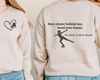 May include: Sand-colored crewneck sweatshirt with a heart and ice skate graphic on the front. The back features a skater silhouette and the text "Dear skater behind me, bend your knees. -the skater in front of you."