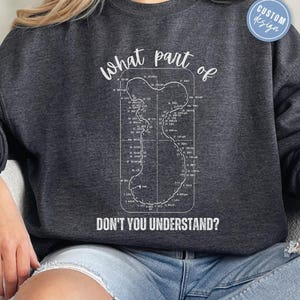 以下が含まれることがあります： 白いレースコースのグラフィックデザインと「what part of DON'T YOU UNDERSTAND?」というテキストが書かれた灰色のスウェットシャツ