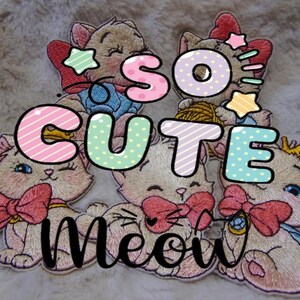 以下が含まれることがあります： ピンクのリボン、星、そして「So Cute Meow」の文字が入った漫画の猫の刺繍パッチ。パッチは様々なポーズで、パステルカラーとふわふわの背景が特徴です。