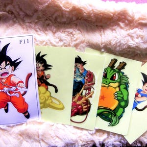 May include: A collection of colorful anime-style stickers featuring characters from Dragon Ball Z. The stickers depict various characters in action poses, with vibrant colors and detailed artwork. One sticker has the text "F11".