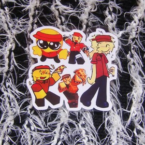 Puede incluir: Una hoja de pegatinas con personajes de dibujos animados de reparto de pizzas en varias poses. Los personajes visten uniformes rojos y amarillos con viseras, sosteniendo porciones y cajas de pizza. El fondo es una superficie texturizada en blanco y negro.