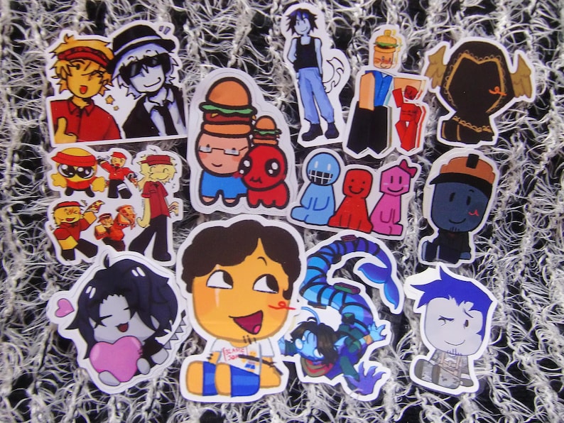 Puede incluir: Una colecci&oacute;n de pegatinas de dibujos animados coloridos con varios personajes y dise&ntilde;os. Las pegatinas incluyen im&aacute;genes de personas, comida y otras ilustraciones caprichosas. Las pegatinas est&aacute;n troqueladas y listas para ser aplicadas.