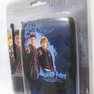 May include: A Harry Potter gaming starter set in a clear plastic package. The blue case features Harry Potter, Ron Weasley, and the Harry Potter logo. The package includes a case, game card, and 2 stylus pens.