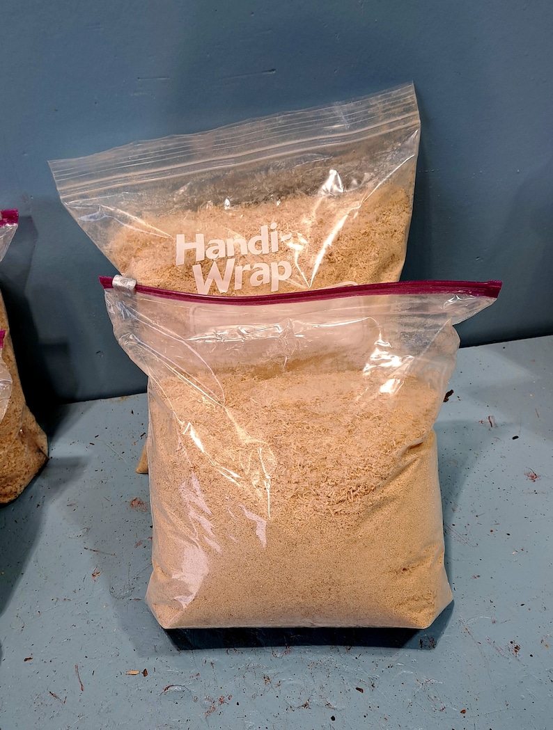 Puede incluir: Dos bolsas de pl&aacute;stico transparente llenas de material granular de color marr&oacute;n claro. Las bolsas est&aacute;n selladas con un cierre de cremallera rojo. Una bolsa est&aacute; apilada encima de otra. La bolsa superior tiene la inscripci&oacute;n "Handi Wrap".