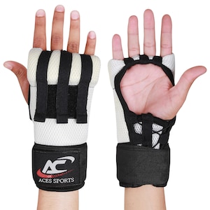 Puede incluir: Un par de vendas de mano acolchadas blancas y negras con una correa de velcro para la muñeca. Las vendas tienen un diseño de malla y la correa de la muñeca tiene el logotipo "ACES SPORTS" en rojo y plateado.