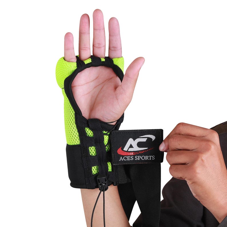 Op de afbeelding: Een groene en zwarte polsbandage met een zwarte band en een klittenbandsluiting. De band heeft een zwart label met de tekst "ACES SPORTS" in witte letters.