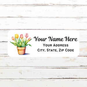 May include: A white label with a watercolor illustration of a potted plant with pink and yellow tulips. The text "Your Name Here" is above the text "YOUR ADDRESS CITY, STATE, ZIP CODE".