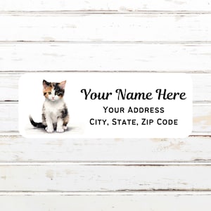 May include: A white label with a watercolor illustration of a calico kitten sitting on a white background. The label has black text that reads "Your Name Here", "Your Address", and "City, State, Zip Code".