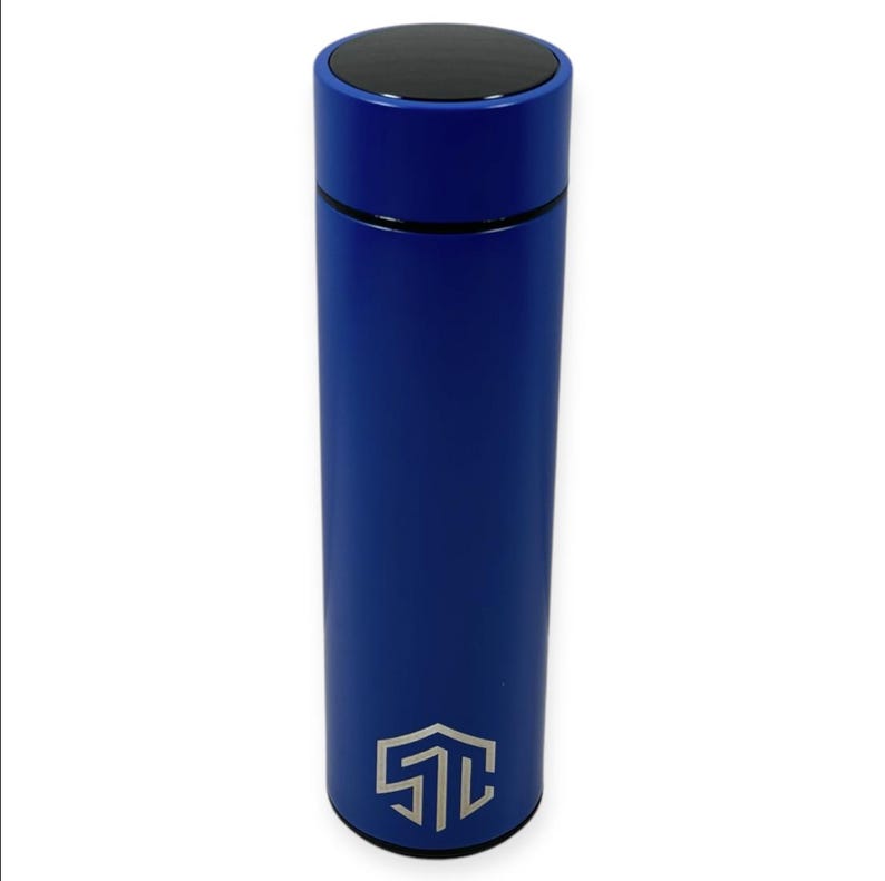 May include: A blue insulated water bottle with a black lid. The cylindrical bottle has a silver logo near the base. The bottle is approximately 10 inches tall.