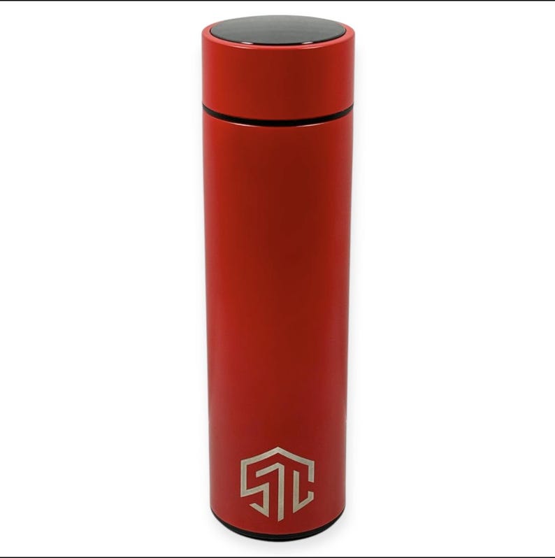May include: A red insulated water bottle with a black lid and a silver logo at the bottom. The cylindrical bottle is made of stainless steel and is designed to keep beverages hot or cold. The bottle is approximately 10 inches tall.