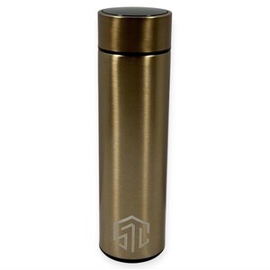 May include: A gold-colored, cylindrical water bottle with a black cap. The bottle has a brushed metal finish and a geometric logo near the base. The bottle is designed to keep beverages cold or hot.