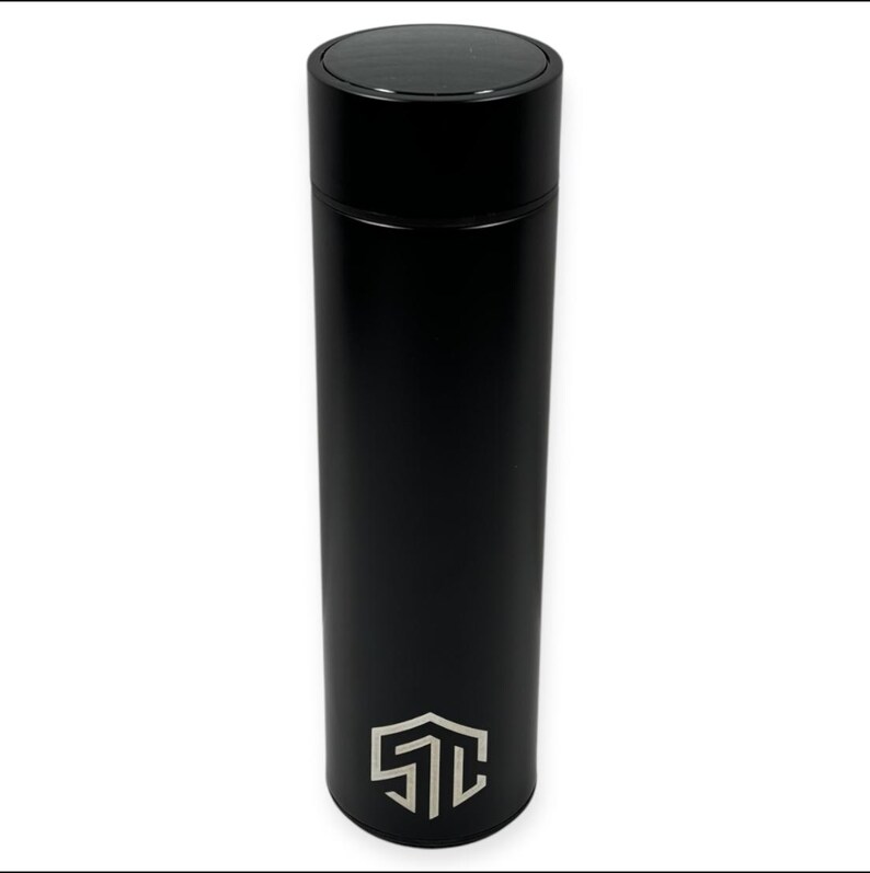 May include: A sleek, black insulated water bottle with a matte finish. The bottle has a black lid and a silver logo near the base. The cylindrical bottle is designed to keep beverages cold or hot. The overall design is modern and minimalist.