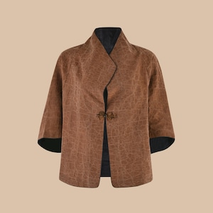 May include: A brown jacket with a textured pattern and a dark blue lining. The jacket has a mandarin collar and a single button closure.
