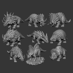May include: A collection of eight grey dinosaur figurines featuring various species with detailed textures, including spiked, armored, and horned designs. Each miniature displays distinct anatomical features like plates, horns, and scales, presented in a neutral grey tone against a dark background.