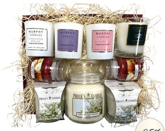 Puede incluir: Una cesta de regalo llena de velas de diferentes tamaños. La cesta incluye cuatro velas pequeñas con etiquetas que dicen "Murphy Candles" y aromas como "Cinnamon Spruce", "Lavender Fields", "Rose Petals" y "Autumn Leaves". También hay una vela grande en un frasco etiquetada como "Price's Candles" con el aroma "Lily of the Valley". La cesta está llena de papel triturado y tiene una etiqueta de descuento del -25%.