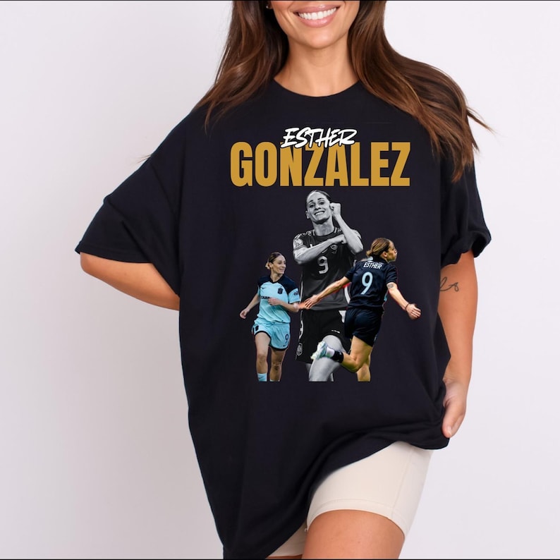 May include: Black t-shirt with the name "Esther Gonzalez" in gold, above a graphic of a soccer player. The player is wearing a jersey with the number 9. A sports-themed apparel item.