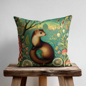 May include: A square throw pillow featuring a brown and cream-colored weasel centered in a lush, colorful forest scene. The illustration includes vibrant green foliage, white bell-shaped flowers, red-capped mushrooms, and tall pink floral stalks.
