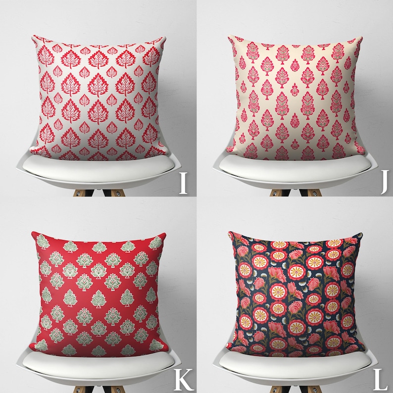 Puede incluir: Cuatro almohadas decorativas con diferentes patrones. Las almohadas son rojas, blancas y azules con dise&ntilde;os florales y de hojas. Las almohadas est&aacute;n en sillas blancas con un fondo blanco.