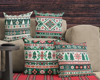 May include: Four square throw pillows featuring a festive holiday pattern in red, green, and white. The designs include repeating motifs of Christmas trees, snowflakes, and geometric shapes arranged in horizontal bands across the fabric surface.