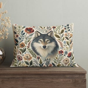 May include: A decorative throw pillow with a white background featuring a wolf's face surrounded by colorful flowers and foliage.
