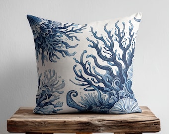May include: A square throw pillow featuring a detailed illustration of deep blue coral reefs and sea shells printed on a white fabric background. The design showcases intricate branching coral patterns and various marine life textures in shades of blue.