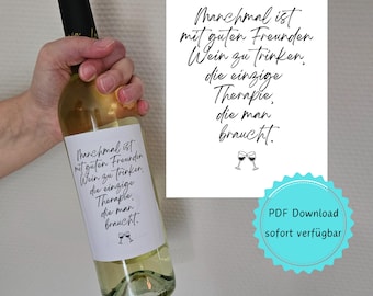 May include: A white wine bottle with a label that reads "Manchmal ist mit guten Freunden Wein zu trinken, die einzige Therapie die man braucht." The label is decorated with a simple drawing of two wine glasses.