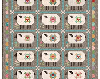 May include: A patchwork quilt with a repeating pattern of sheep, each with a heart-shaped design. The quilt has a grey background, a blue border, and floral accents. The quilt is square in shape, suitable for a bed or wall hanging.