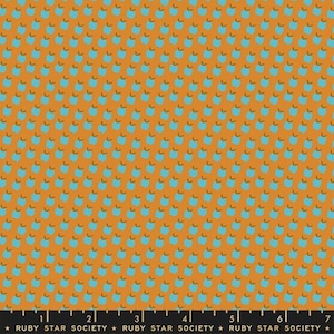 Könnte beinhalten: Orangener Stoff mit einem sich wiederholenden Muster aus kleinen, stilisierten blauen Apfelformen mit braunen Stielen. Der Stoff hat unten ein Lineal mit dem Text "RUBY STAR SOCIETY".