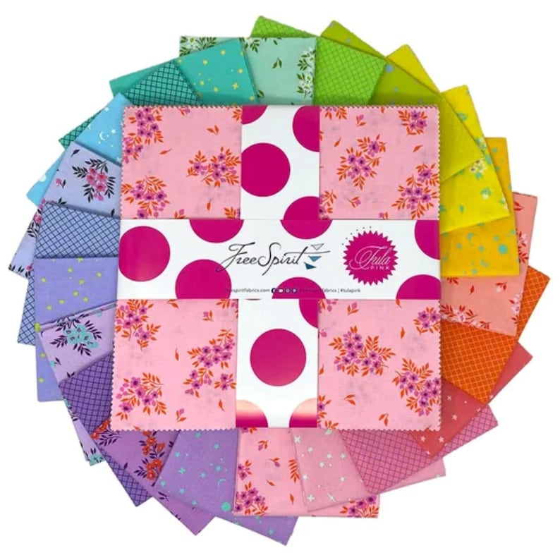 May include: A collection of colorful fabric squares arranged in a circular pattern. The squares feature floral and polka dot patterns in shades of pink, purple, green, and yellow. The center displays the "Free Spirit" logo and "Tula Pink" branding.
