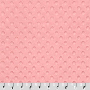 Pu&ograve; includere: Un primo piano di un tessuto rosa con un motivo testurizzato a pois. Il tessuto &egrave; morbido e soffice, perfetto per progetti di artigianato o cucito.