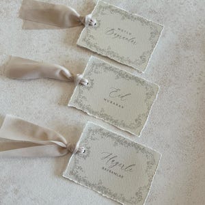 Pu&ograve; includere: Tre etichette regalo beige con bordi strappati e bordi floreali. Ogni etichetta ha un nastro beige attaccato. Le etichette hanno il testo: "Mutlu, Beğenler", "Eid, Mubarak" e "Hayırlı, Bayramlar".