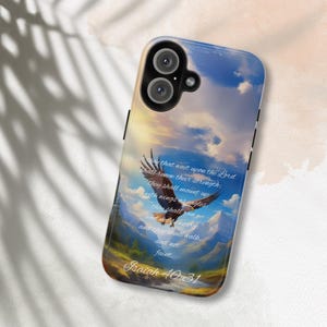 May include: A phone case with a blue sky and clouds background. An eagle with outstretched wings is flying in the sky. The text "They that wait upon the Lord shall renew their strength: they shall mount up with wings as eagles: they shall run and not be weary; and they shall walk and not faint. Isaiah 40:31" is printed on the case.
