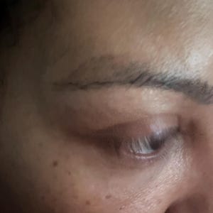 May include: Close-up of a person's face, showing a single eye with dark eyelashes and a defined eyebrow. The skin is light-toned and has a few freckles.