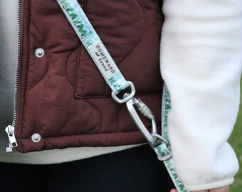 May include: A white and green patterned dog leash with a silver clip. The leash has the text "Homeward Bound" printed on it.