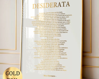 May include: A gold foil print of the poem "Desiderata" by Max Ehrmann. The poem is printed on a white background with a gold frame. The poem is about living a peaceful and fulfilling life.