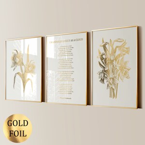 May include: Three framed art prints with gold foil accents. The prints feature gold illustrations of daffodils and a poem titled "I Wandered Lonely as a Cloud" by William Wordsworth. The frames have a gold border and are displayed on a light background.
