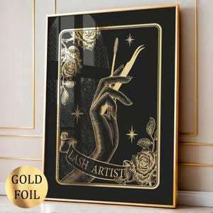 Op de afbeelding: Gouden folie print op zwarte achtergrond, met een hand die wimpertools vasthoudt. De woorden "LASH ARTIST" staan op een banner. Rozen en sterren versieren het ontwerp. De lijst is goudkleurig.