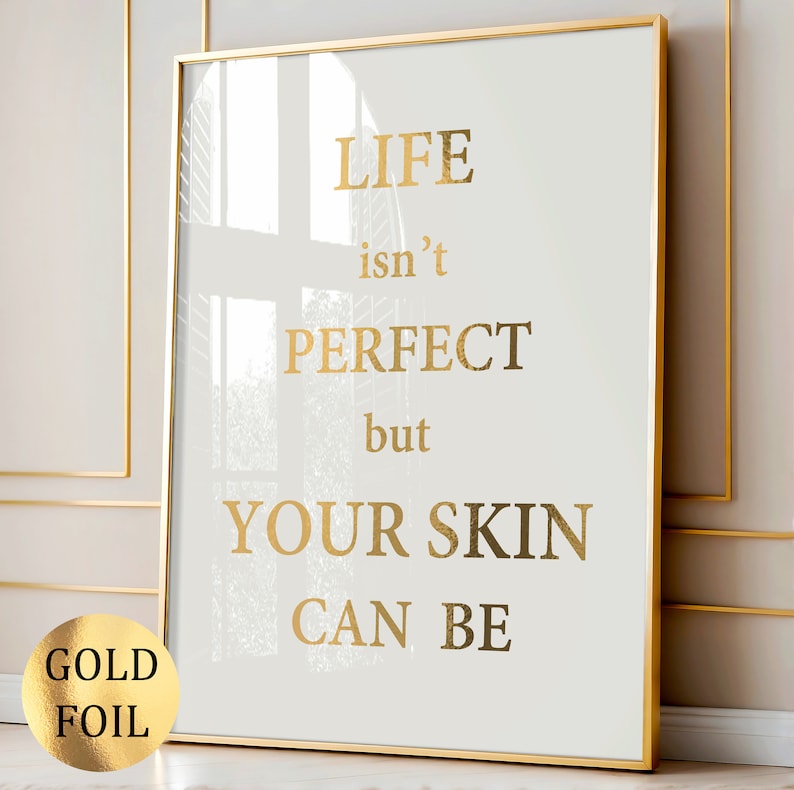 May include: Gold foil print with the text "LIFE isn't PERFECT but YOUR SKIN CAN BE" on a white background in a gold frame.
