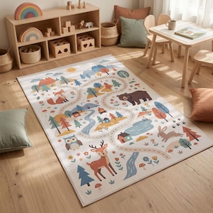 Puede incluir: Una alfombra rectangular con fondo claro y un estampado colorido de temática forestal. El diseño incluye ilustraciones de un zorro, un oso, un búho, un ciervo y un conejo, junto con senderos sinuosos, árboles, montañas y pequeñas casas.