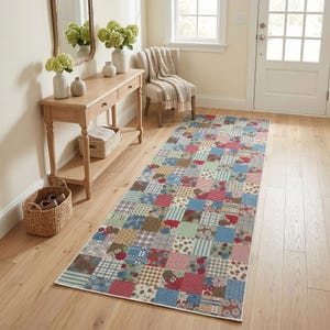 May include: A long rectangular runner rug featuring a multi-colored patchwork design with various floral, plaid, and striped patterns in shades of red, blue, green, and beige, laid out on a light-toned wooden floor in a hallway setting.