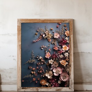 May include: A framed artwork featuring a 3D floral arrangement with pink, red, and gold paper flowers on a blue background.